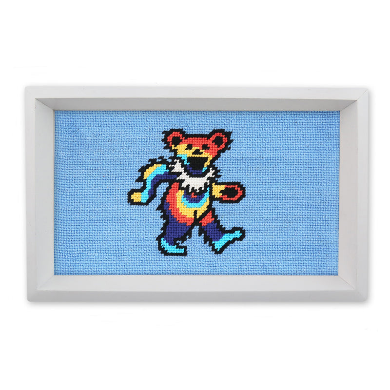 Framed cross-stitched artwork of a colorful bear on a blue background