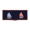 Navy needlepoint patch with sailboat designs on a white background